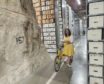 Dr Colleen Shogan next to tricycle in archives